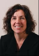 Commissioner Beth Hansen with dark brown wavy hair and black shirt.